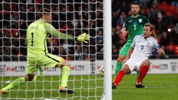 England's Harry Kane, right, scores a goal against Slovenia goalkeeper Jan Oblak.