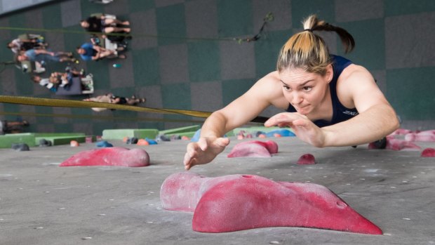 Oceana Mackenzie jumps and grasps for a hold in sport climbing practice for the Tokyo Olympics. 