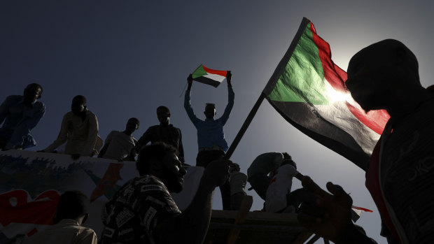 People celebrate the first anniversary of mass protests that led to the ouster of the former president Omar al-Bashir in Khartoum, last year.