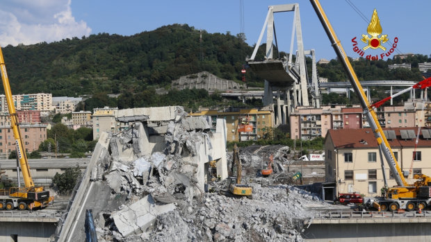 Firefighters remove rubble of the collapsed Morandi highway bridge, in Genoa, Italy, on Saturday.