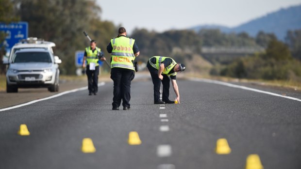 Victoria Police officers investigate a crash on the Hume Freeway in 2017.