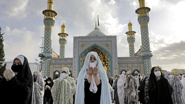 Worshippers wearing protective face masks offer Eid al-Fitr prayers outside a shrine to help prevent the spread of the coronavirus, in Tehran in May.