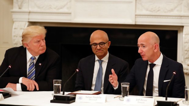 Donald Trump (with Microsoft CEO Satya Nadella in the centre) and Amazon boss Jeff Bezos.