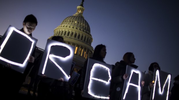 Demonstrators hold illuminated signs during a rally supporting the Deferred Action for Childhood Arrivals program (DACA), or the Dream Act, outside the US Capitol building in Washington, DC.
