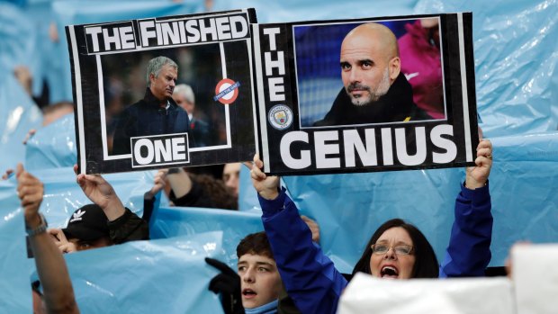 No contest: Manchester City supporters hold up pictures of Mourinho and City coach Pep Guardiola.