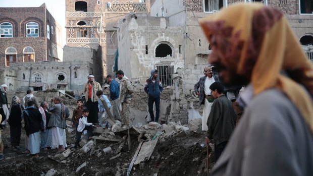 People stand on the rubble of houses at the site of a Saudi-led airstrike near Yemen's Defence Ministry complex in Sanaa, Yemen, in November.