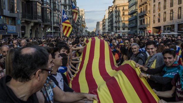 Demonstrators wave a large Catalan flag while marching through Barcelona in October.