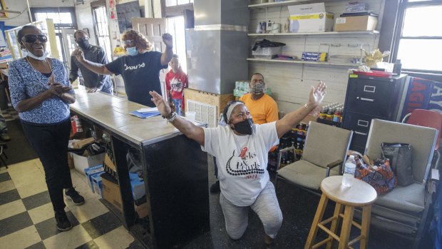 Gail Russell, 68, falls to her knees and proclaims “Thank you, Jesus” at Gloria’s Corner Store in New Orleans, as she listens to the verdict on TV.