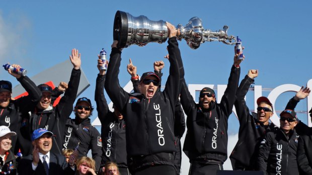 Oracle Team USA skipper Jimmy Spithill holds up the Auld Mug as they celebrate in the podium after winning the America’s Cup in 2013 in San Francisco. 