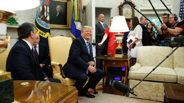 President Donald Trump laughs during a meeting with Uzbek President Shavkat Mirziyoyev in the Oval Office of the White House in May.
