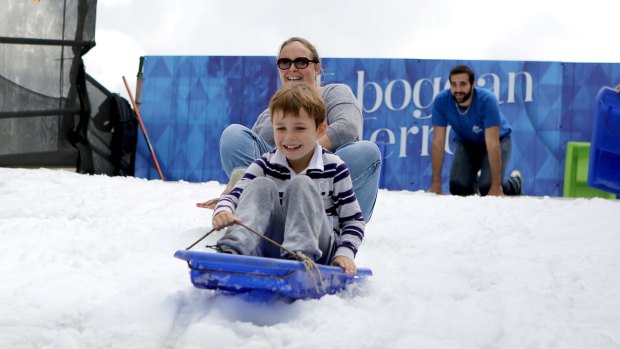 A mother and her son try out a toboggan at the Winter Festival in Brisbane.