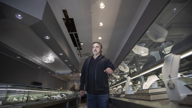 Brian Hassine, owner of Nuggets and Carats jewelry, stands near a hole in the ceiling where Chilean burglars broke in through the roof and stole more than $US1 million worth of jewelry and diamonds in Laguna Niguel, California.
