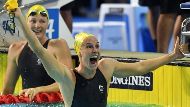 Bronte Campbell celebrates her gold win as sister Cate looks on.