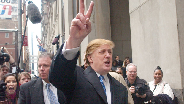Donald Trump, then known as a billionaire developer, waves to reality TV show hopefuls outside Trump Tower in New York.