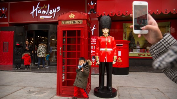A boy poses for a photo outside of Hamleys toy store in Beijing. The store is twice the size of the British toy retailer's flagship London location.