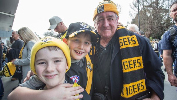 Richmond supporters Mitch Humphries and Liam James wait in line at the MCG with their great uncle Syd James.
