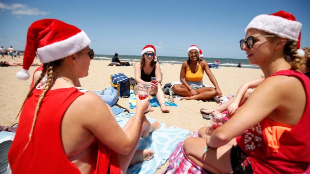 Revellers enjoy a warm Christmas Day at St Kilda beach last year. 