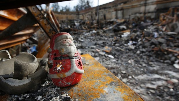 A Christmas decoration sits among the burned ruins of a California house after a 2018 wildfire.