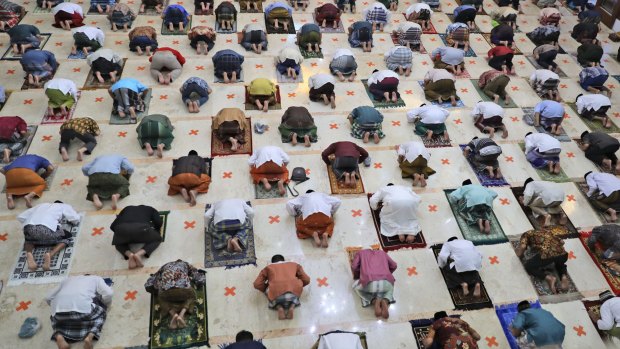 Indonesian Muslims pray spaced apart as they practice social distancing in Sidoarjo, East Java, Indonesia.