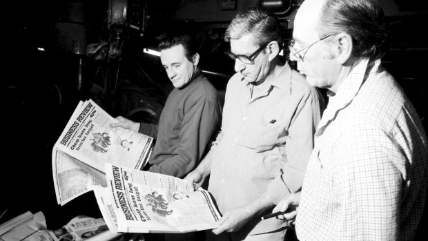 Bob Dempsey, National Times production editor, Evan Whitton, Editor, and Vic Carroll, right, look over the first printing of the National Times Business Review.