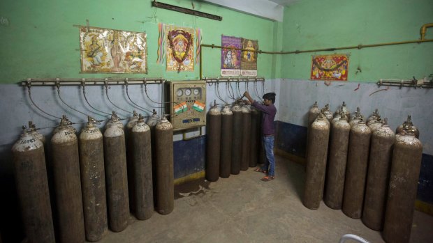 A hospital staff member checks newly arrived oxygen cylinders at Baba Raghav Das Medical College Hospital in Gorakhpur after the deaths last year.