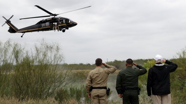 President Donald Trump salutes as a US Customs and Border Protection helicopter passes in McAllen, Texas. 