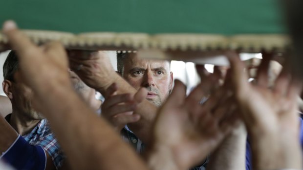 Bosnian Muslims carry one of 127 coffins with identified victims of the Srebrenica massacre in 2016.