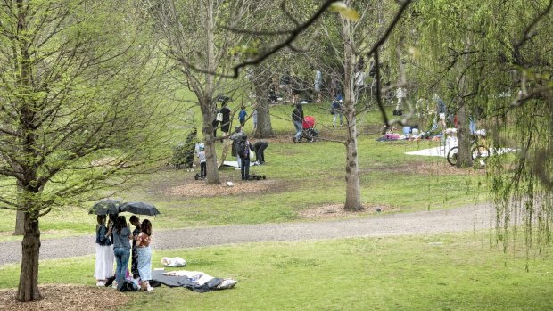 Picnics are packed up as the rain begins to fall at Centennial Park.