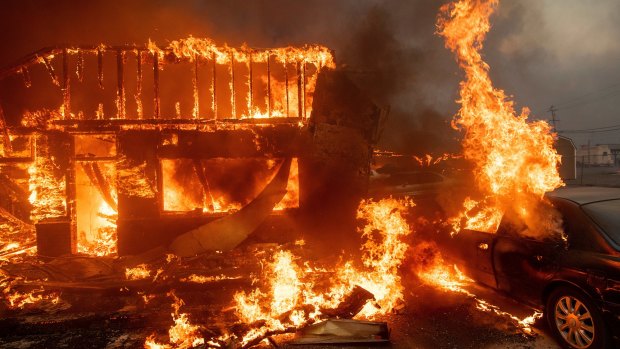 Flames consume a car and building in Paradise, California on November 8. 