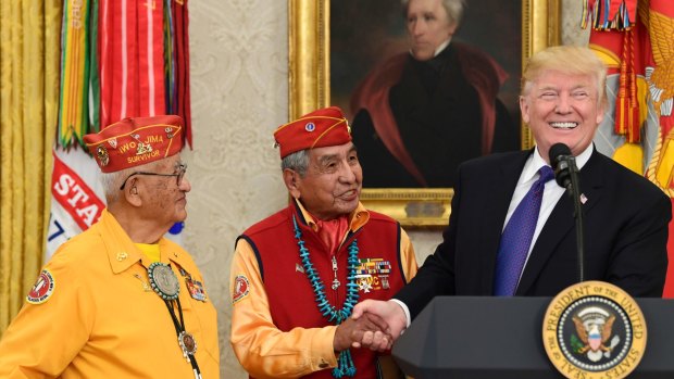 US President Donald Trump, right, meets with Navajo Code Talkers Peter MacDonald, center, and Thomas Begay, left, in the Oval Office last year.
