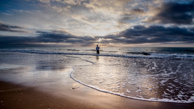 A fisherman at dawn on Paradise Beach.