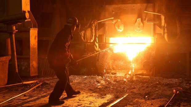 A worker cleans slag from an electric arc furnace in a steel plant in Russia. 