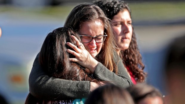 Students released from a lockdown embrace following a shooting at Marjory Stoneman Douglas High School in Parkland, Florida.