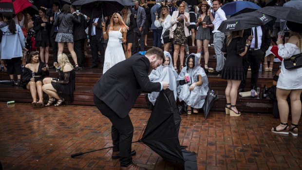 Punters  take cover at a wet 2019 Derby Day, Flemington Racecourse. 