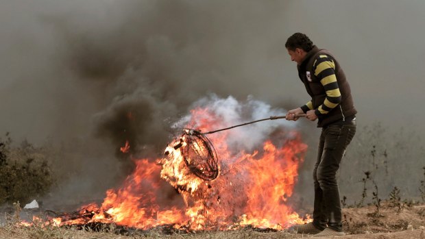 A Palestinian protester burns tyres next to Gaza's border with Israel earlier this month.