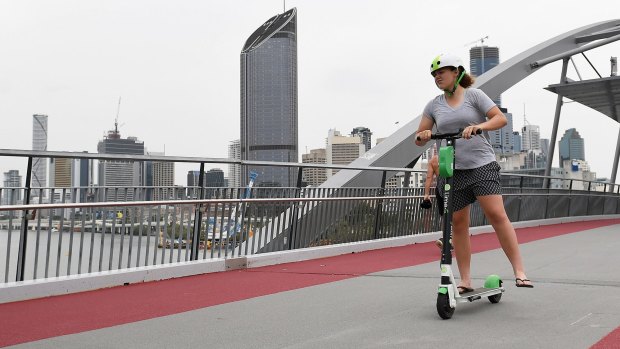 Lime users ride scooters through Goodwill Bridge in Brisbane, Tuesday.