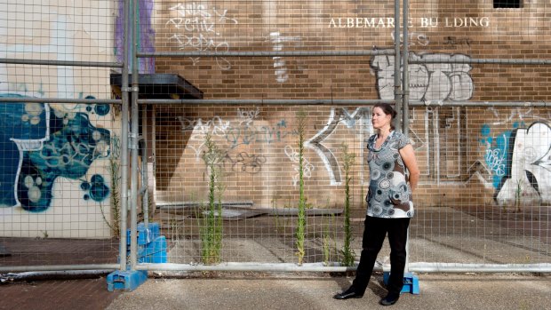 Woden Valley Community Council president Fiona Carrick in front of some of Woden's derelict buildings. The Woden community is banking on light rail for urban renewal.