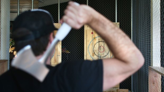 Adam Schilling, co-owner of Maniax, gets ready to throw an axe at one of the targets.