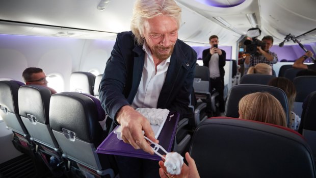Towel boy: Sir Richard Branson handing The Goss a hot towel on the world's first dedicated meditation flight on Thursday.