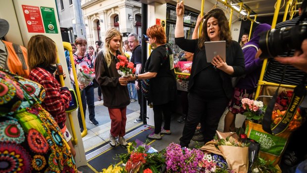 Mourners bring flowers onto the 86 tram as part of a vigil for Aiia Maasarwe in January.
