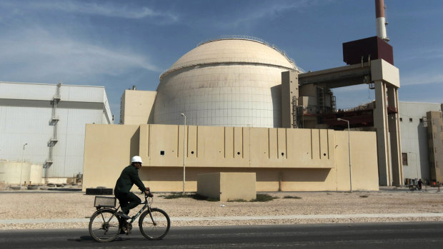A worker rides a bicycle in front of the reactor building of the Bushehr nuclear power plant, in Iran, in 2010.