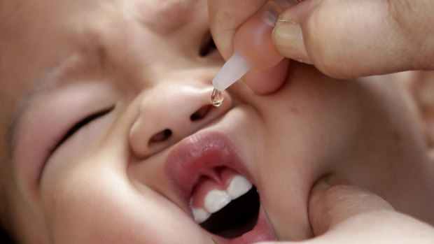 A local health worker administers a vaccine to a baby at a local health centre in Manila.