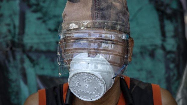 A man is seen wearing a makeshift mask made out of a styrofoam cup and a faceshield made out of a plastic bottle to protect against COVID-19 in Manila, Philippines. 