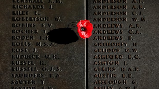 A poppy is placed on the Roll of Honour after the ANZAC Day dawn service at the Australian War Memorial.