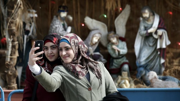 Muslim women take a selfie in front in Manger Square in front of the Church of the Nativity, revered as the site of Jesus Christ's birth, in the West Bank town of Bethlehem.