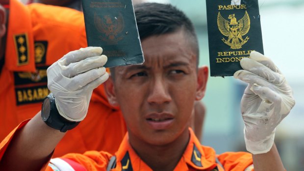 A rescuer shows passports recovered from the area where a Lion Air plane is suspected of crashing. 