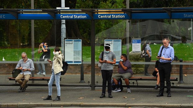 People wait for buses near Central Station after all Sydney Trains and Trainlink services were stopped on Monday.