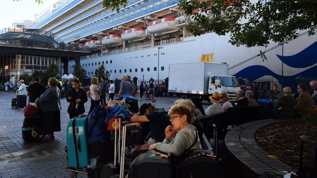 Passengers sit with their luggage after disembarking from the Ruby Princess cruise ship on March 19 at Sydney's Circular Quay.