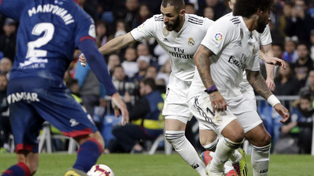Real Madrid's Karim Benzema, centre, moves to score his side's third goal during a Spanish La Liga soccer match between Real Madrid and Huesca in Madrid on Sunday local time.