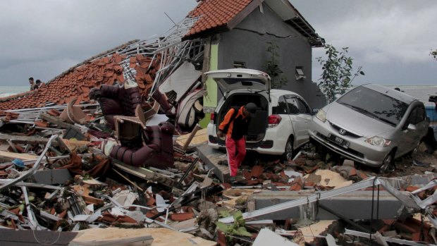 A man inspects the damage suffered by a building following a tsunami in Anyar, Indonesia.